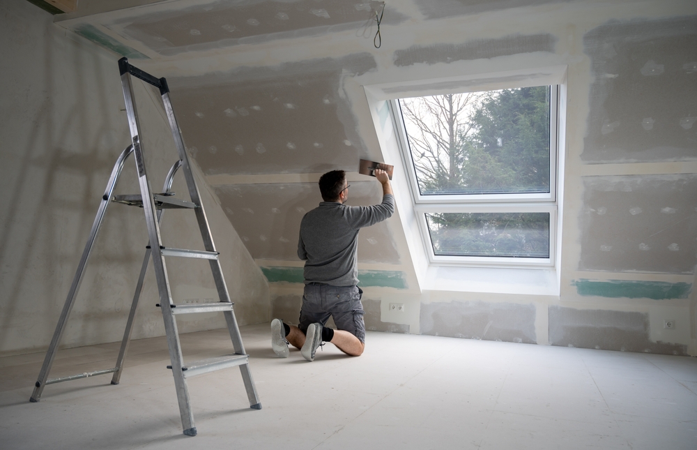 Loft conversions in Sussex with interior plastering and roof light installation in progress